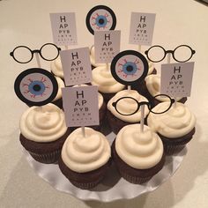 cupcakes with eye glasses and stickers on them are arranged in a circle