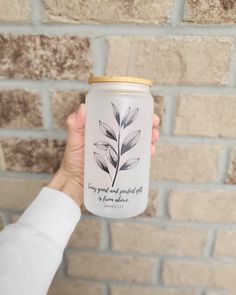 a person holding up a can with a plant on it