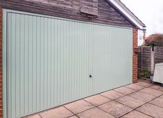 a garage door is open on a brick patio with a table and chairs in the background