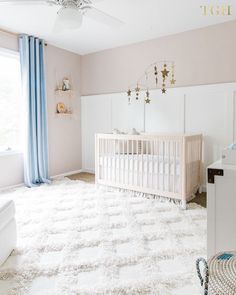 a baby's room with a crib, dresser and bed in it that has blue drapes on the windows