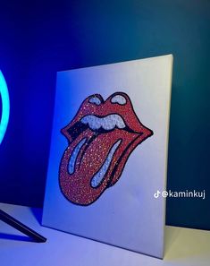 the rolling stones'tongue is lit up in blue and red lights on a white surface