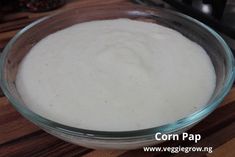 a glass bowl filled with batter on top of a wooden table