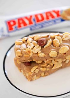 two pieces of peanut butter granola bars on a plate with a candy bar in the background