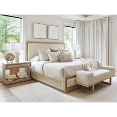 a large white bed sitting in a bedroom next to a window