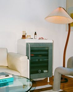 a living room filled with furniture and a lamp on top of a hard wood floor