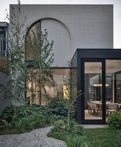 an outdoor dining area is shown in the foreground, and on the far side there is a brick walkway that leads up to the back door