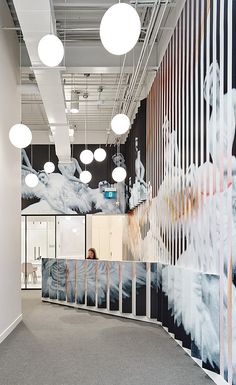 an office space with colorful wallpaper and hanging lights above the door, along with two elevators