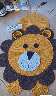 a rug with a bear face on the floor next to some paint bottles and scissors