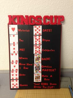 a wooden sign that says kings cup with playing cards in red and white on it