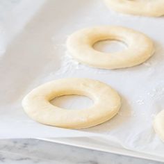 doughnuts are sitting on top of wax paper