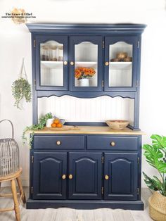 a blue china cabinet with wooden top and drawers