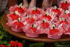 red and white cupcakes are arranged on a cake platter with candy wrappers