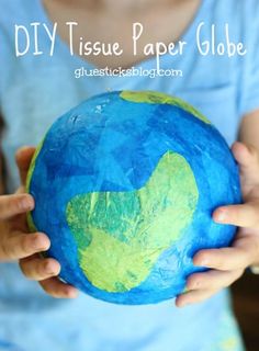 a child holding up a paper globe with the words diy tissue paper globe on it