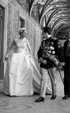 an old photo of a man and woman dressed in formal clothing standing next to each other