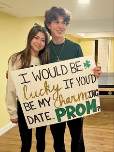 two people holding a sign that says i would be lucky if you'd be my charming date prom