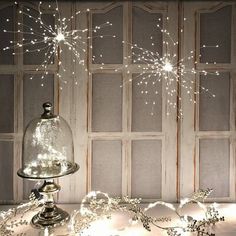 a table topped with a cake covered in frosted icing and sparkles under a glass dome