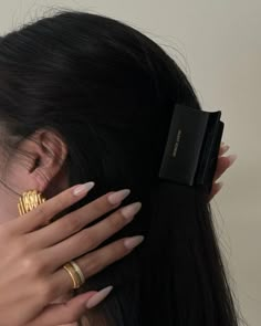 a close up of a person with rings on their fingers and her hair pulled back