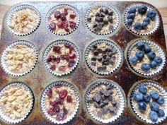 muffin tins filled with oatmeal and blueberries on a table