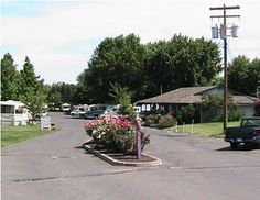 an rv park with cars parked on the side of the road and trees in the background