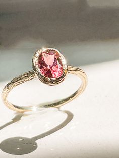 The Tara is a pink tourmaline and 14k gold ring. The cut of the stone is in an Old World European style that is rare and difficult to find. The stone size is approximately 7mm by 4mm. The ring and bezel are hand cast and etched by a third generation goldsmith in Los Angeles.  Please send me a message if you would like a larger or smaller size. This is a custom made ring and is not available for returns. Thank you for your understanding. Each order comes in a jewelry pouch within a Kraft jewelry Pink Oval Tourmaline Jewelry, Oval Tourmaline Solitaire Jewelry, Oval Solitaire Tourmaline Jewelry, Oval Pink Tourmaline Ruby Ring, Heirloom Oval Tourmaline Ring, Oval Tourmaline Sapphire Ring For Gifts, Pink Gold Oval Ruby Ring With Gemstone, Oval Rose Gold Tourmaline Ring, Rose Gold Oval Tourmaline Rings