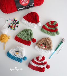 crocheted hats and other items are on the table next to a ball of yarn