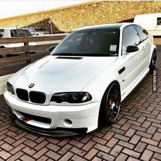 a white car parked on top of a brick road