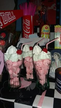 three pink ice cream sundaes sitting on top of a black and white checkered table