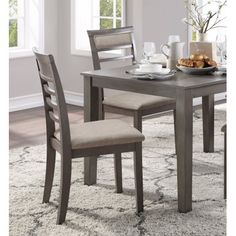 a dining room table with two chairs and a bowl of food on the table next to it