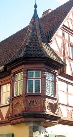 an old building with a clock tower on the top of it's roof and windows