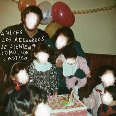 a group of people sitting around a table with a cake on it and balloons in the background