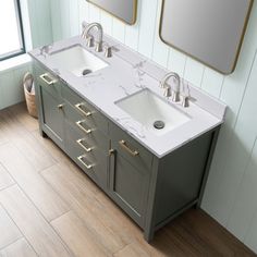 two sinks and mirrors in a bathroom with wood flooring