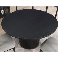 a black table with four chairs around it and a rug on the floor next to it