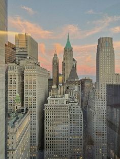 the city skyline is lit up at sunset with skyscrapers in the foreground and pink clouds in the sky