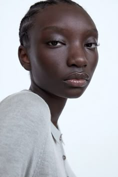 a woman with braids on her hair and eyeshade looking at the camera