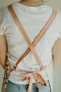 the back of a woman's white shirt with an orange ribbon tied around her waist