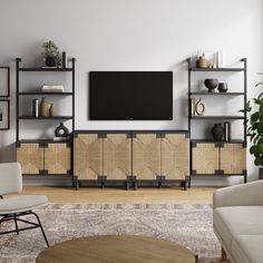 a living room with furniture and a flat screen tv mounted on the wall above it