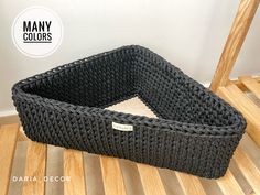 a black basket sitting on top of a wooden floor