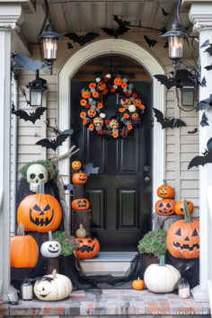 a front porch decorated for halloween with pumpkins and decorations