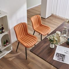 two orange chairs sitting on top of a wooden table