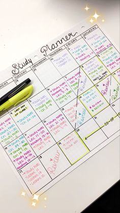 a sticky calendar with writing on it and a pen resting on the top of it