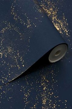 a roll of black paper with gold sprinkles on the ground next to it