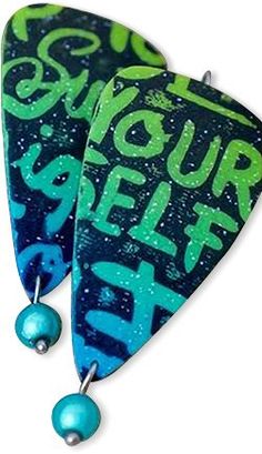 two blue and green guitar picks with the words your self be on them, hanging from hooks