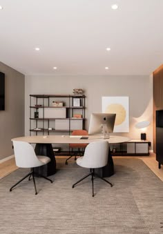 an office with two chairs, a desk and a book shelf in the middle of the room