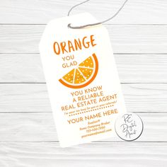 an orange gift tag on a white wooden background with the words, orange you glad? you know a real estate agent for your name here