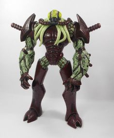 an action figure is shown on a white background with green and red accents, including two large horns