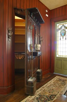 an antique grandfather clock in the corner of a room with wood paneling and stained glass windows