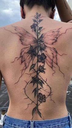 a woman's back with flowers and leaves on it