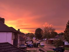 cars parked on the side of a road at sunset or dawn with clouds in the sky