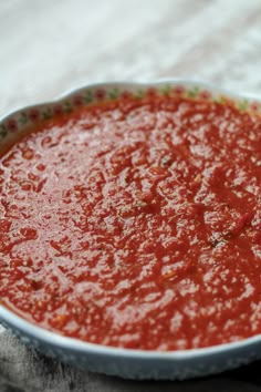 a bowl of marinara sauce sitting on top of a table