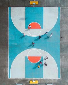 an overhead view of a basketball court with people playing on it and one person standing in the middle